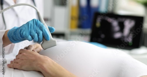 Pregnant woman undergoes ultrasound in clinic closeup. Examination of fetus of child concept