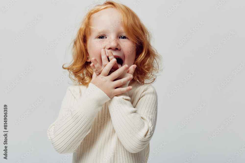 Innocent little girl with red hair expressing astonishment in front of white background Innocent little girl with red hair expressing astonishment in front of white background