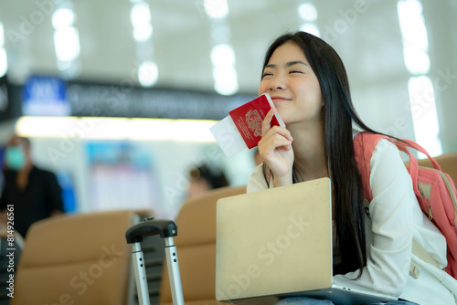 Happy Traveling young female tourist and showed her passport in hand at the airport, female tourist passenger feel happy and excited to go travel, traveler concept.