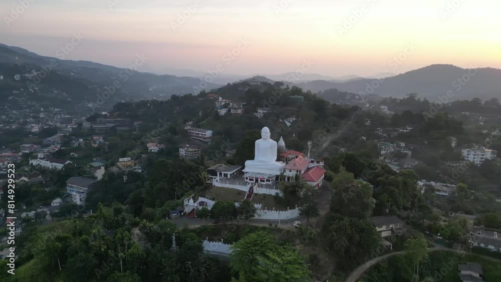 Drone pov of big white sitting Buddha overlooking the green lush hills around Drone pov of big white sitting Buddha overlooking the green lush hills around