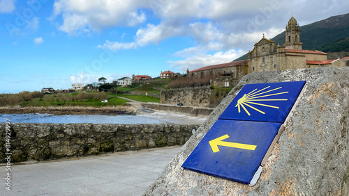 The sea and a sign for the Camino de Santiago along the coast, in Oia