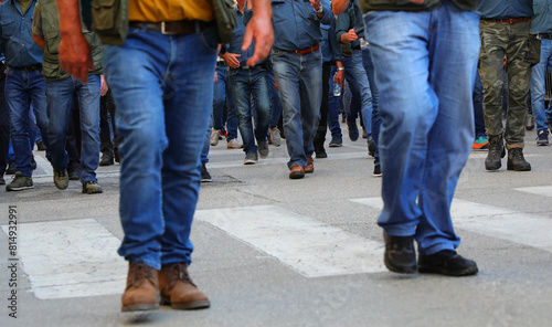 crowd of men walking down the street in jeans and their faces cannot be seen