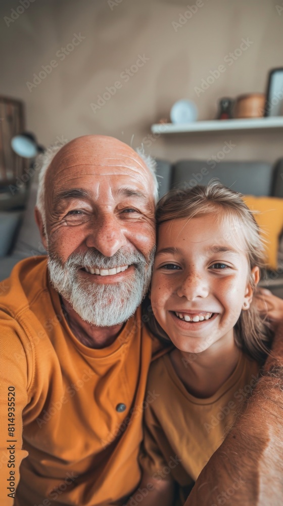 A joyful moment captured between a smiling older man with a white beard and a young girl both sharing a warm embrace in a cozy living room setting. A joyful moment captured between a smiling older man with a white beard and a young girl both sharing a warm embrace in a cozy living room setting.