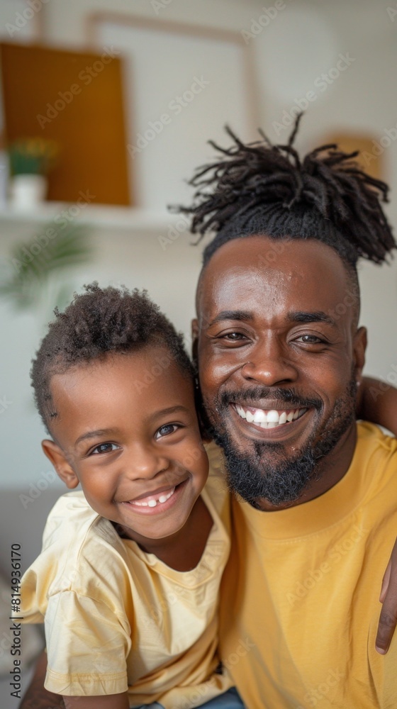 A joyful moment captured between a father and his son both smiling broadly with the father's dreadlocks adding a unique touch to their shared happiness. A joyful moment captured between a father and his son both smiling broadly with the father's dreadlocks adding a unique touch to their shared happiness.