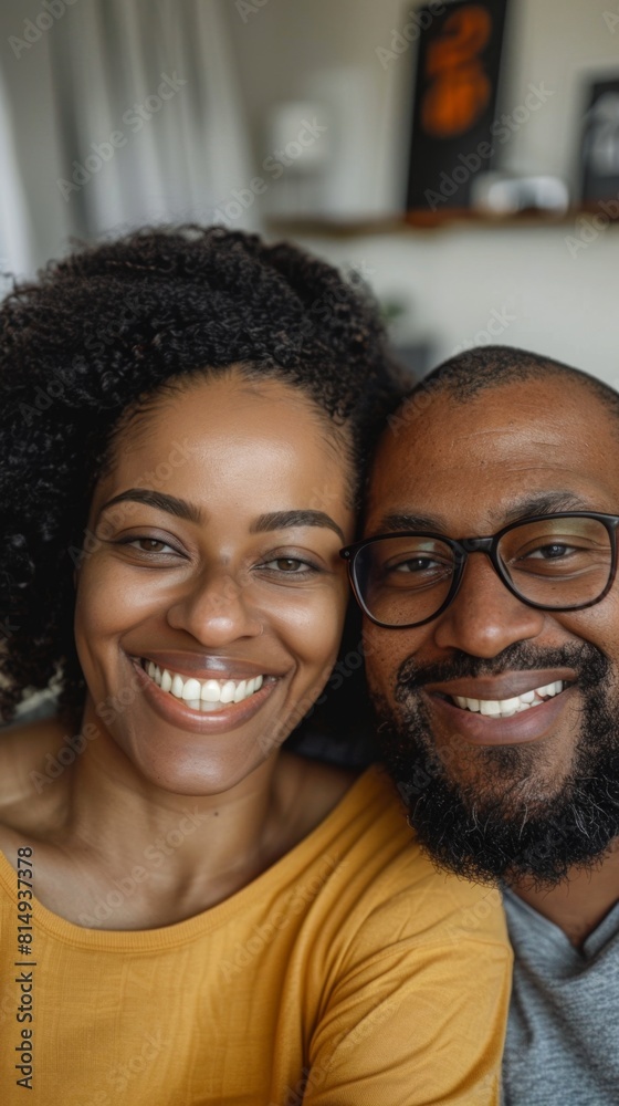 A joyful couple sharing a warm smile their happiness radiating in a cozy room with soft lighting. A joyful couple sharing a warm smile their happiness radiating in a cozy room with soft lighting.