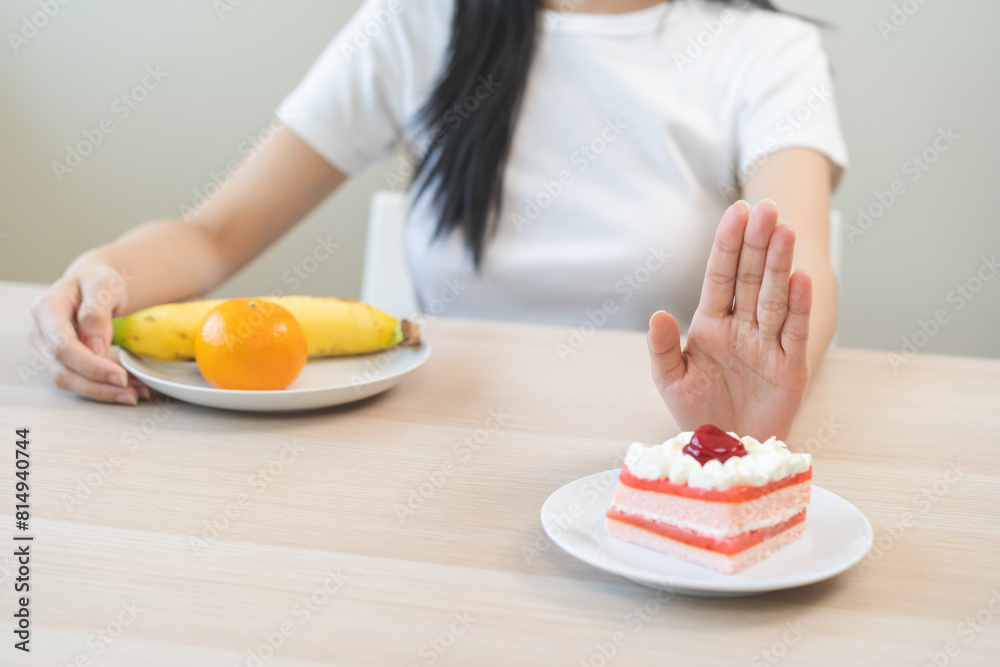 Diet asian young woman, girl hand push out, refuse eat piece strawberry cake, sweet or dessert taste, choose eat fruit, fighting to keep it from getting fat. Fast food unhealthy of weight loss concept Diet asian young woman, girl hand push out, refuse eat piece strawberry cake, sweet or dessert taste, choose eat fruit, fighting to keep it from getting fat. Fast food unhealthy of weight loss concept