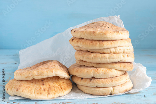 Freshly baked pita bread on blue wooden background.
