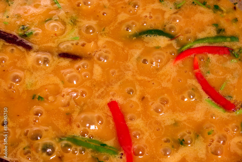 Adding boiling dal lentil into bagar tadka with deep fry tomato onion garlic cumin red dry chilli spice stair cooking dal ghotni whisk 