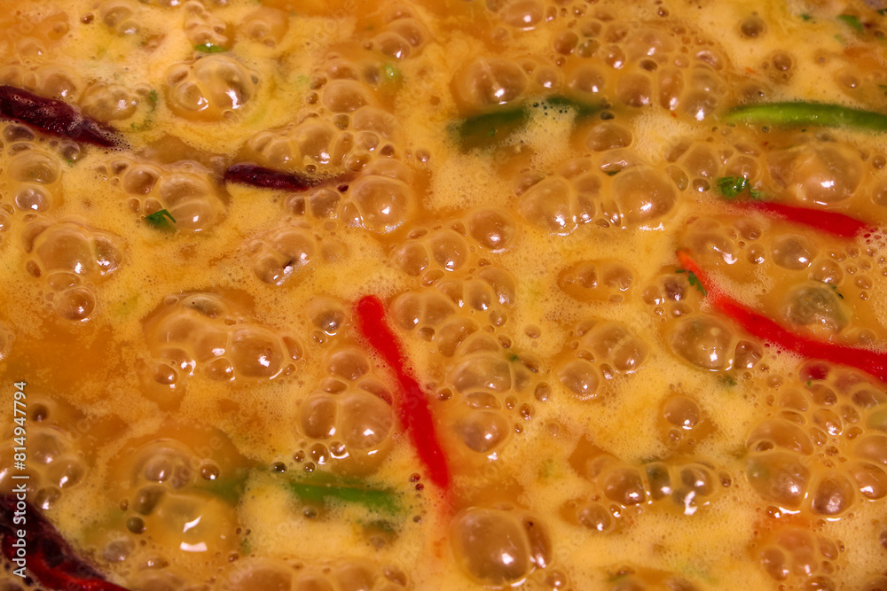 Adding boiling dal lentil into bagar tadka with deep fry tomato onion garlic cumin red dry chilli spice stair cooking dal ghotni whisk Adding boiling dal lentil into bagar tadka with deep fry tomato onion garlic cumin red dry chilli spice stair cooking dal ghotni whisk