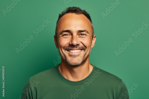 Portrait of a smiling man in his 40s smiling at the camera over pastel green background © Markus Schröder