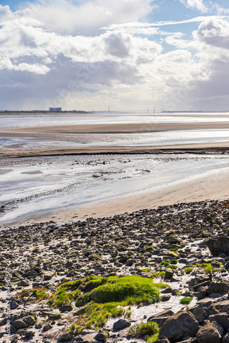 Obraz na płótnie A view across the Severn Estuary at low tide towards Oldbury Power Station and the Severn bridges seen from Lydney Harbour, Gloucestershire, England UK w salonie