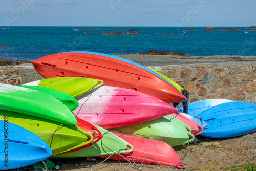 Colorful sea kayaks on the shore in Cobo bay, Guernsey, CHannel Islands