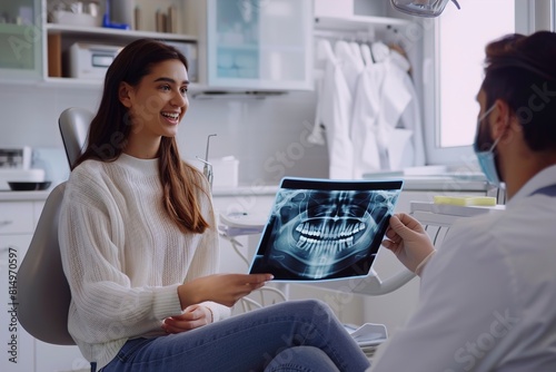 Young dentist showing x-ray to patient photo