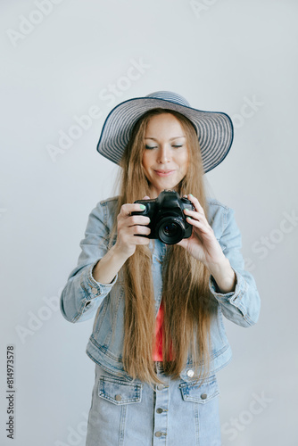 Smiling Woman Photographer with dslr Camera over studio plain background