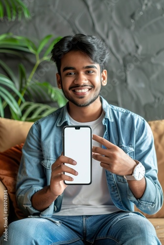 Cheerful Indian Guy Showing Smart phone With Big Blank