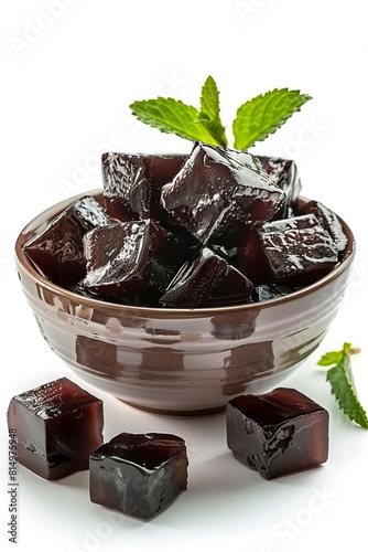 Delicious grass jelly cubes in bowl on white background photo