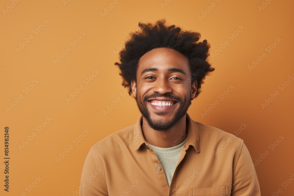 Portrait of a merry afro-american man in his 30s smiling at the camera on pastel brown background Portrait of a merry afro-american man in his 30s smiling at the camera on pastel brown background