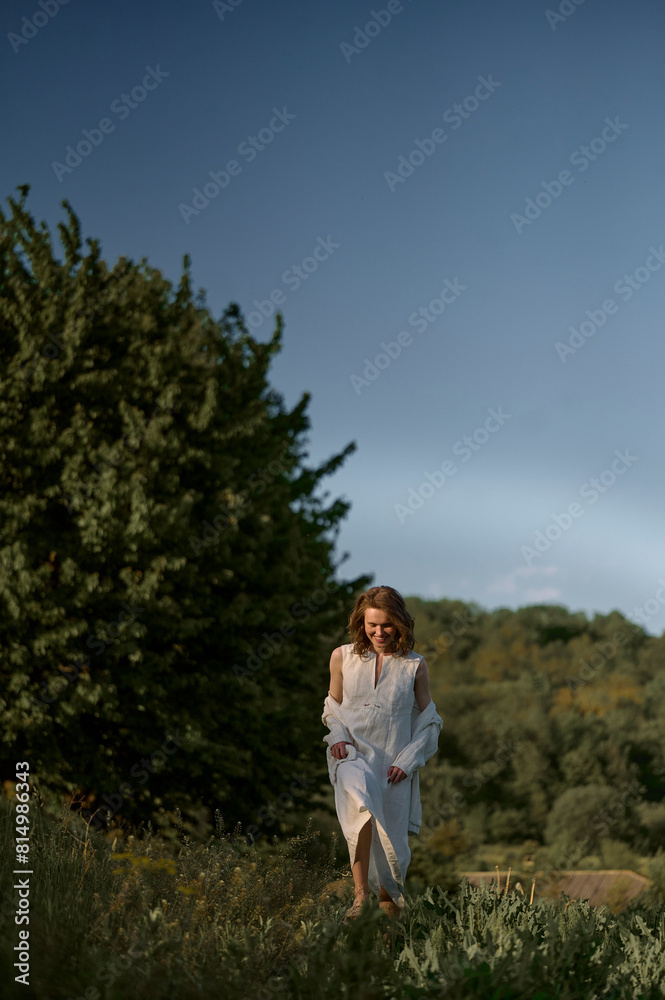 pretty woman in white dress and sweater walking in nature pretty woman in white dress and sweater walking in nature