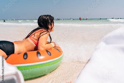 Girl laying on top of a watermelon raft.  photo