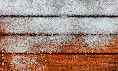 Outdoor deck wooden boards covered with snow and ice during winter