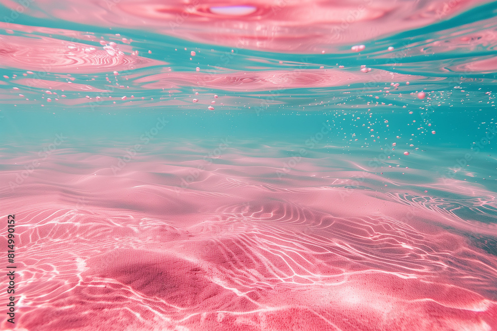 Pink and turquoise water under the sea, with light reflection on ripples. A pink sand bottom is visible. Travel and summer concept.