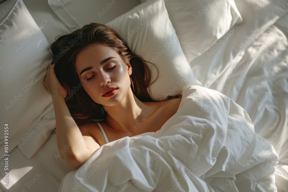 Tranquil scene of a young woman sleeping soundly surrounded by soft, white bedding Tranquil scene of a young woman sleeping soundly surrounded by soft, white bedding