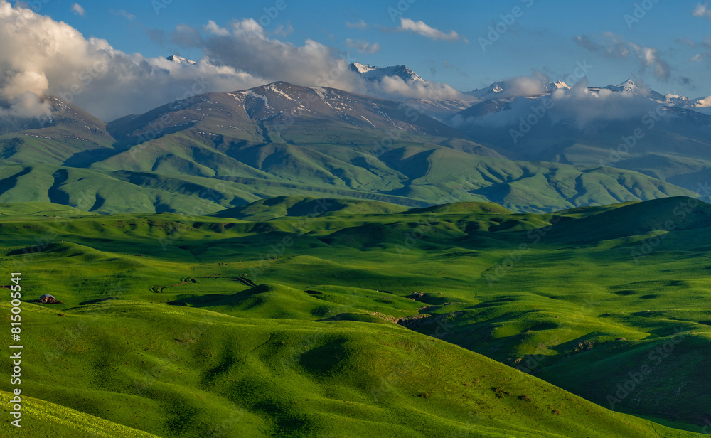 Fototapeta premium A picturesque plateau against the backdrop of snow-covered peaks in the Trans-Ili Alatau (Kazakhstan)