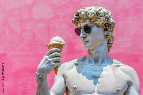 David Greek statue with sunglasses amusingly holds an ice cream cone against a vibrant pink bubble wrap background for a playful contrast photo