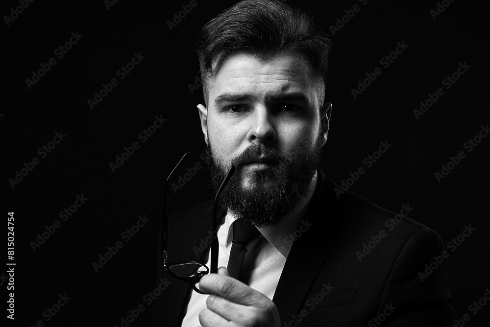 Portrait of a successful businessman on a black background. Grain effect used Portrait of a successful businessman on a black background. Grain effect used