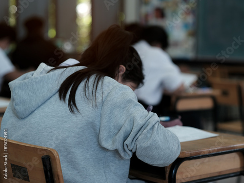 Assessment examination of high school students dressed in uniform.The students were doing the exams inside the classroom with stress.