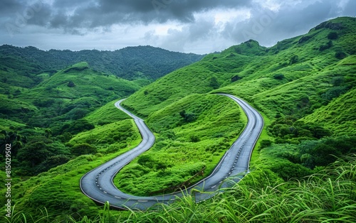 Winding road through lush green hills under a cloudy sky.
