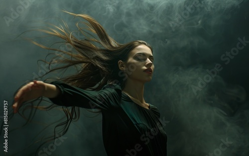 Woman with flowing hair dancing in dark  moody backdrop.