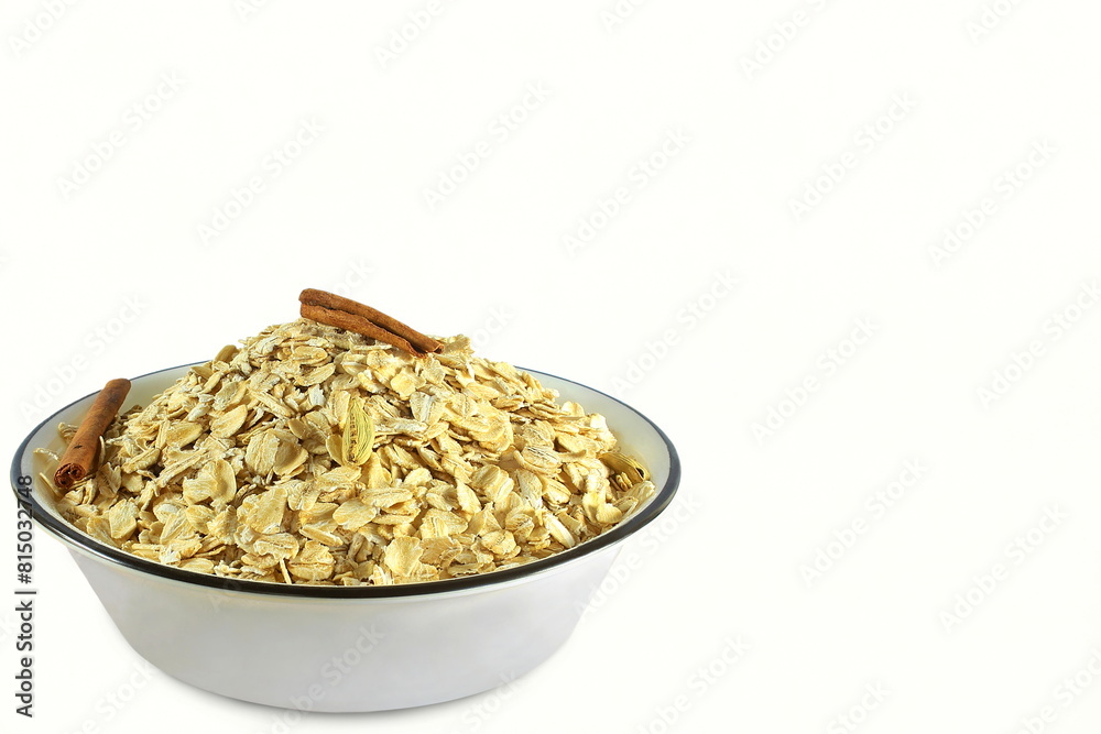 rolled oats flakes isolated for breakfast in bowl with cinnamon,white background,copy space,top view rolled oats flakes isolated for breakfast in bowl with cinnamon,white background,copy space,top view