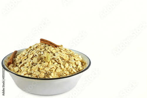  rolled oats flakes isolated for breakfast in bowl with cinnamon,white background,copy space,top view