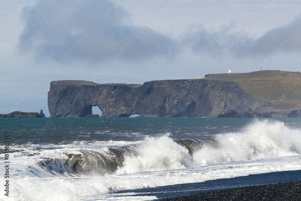 Obraz premium waves crashing at the black sand beach of Reynisfjara with an stunning mountain range in the distance, Iceland