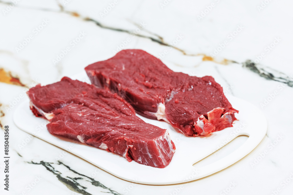 Raw meat for steak on cutting board. Top view. Raw meat for steak on cutting board. Top view.