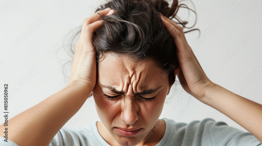 A person clutches their head eyes squeezed shut with a look of utter overwhelm on white background