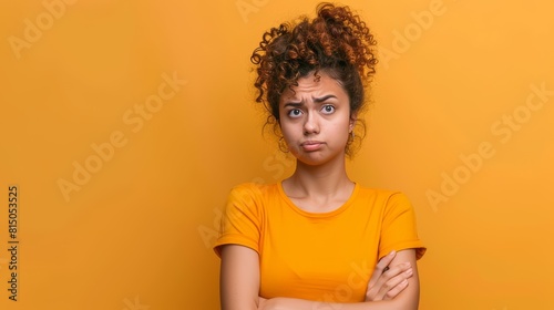 A person crosses their arms looking unconvinced with a raised eyebrow