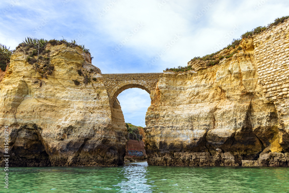 Pinhao Fort Bridge, an ancient stone bridge at Praia dos Estudantes Beach, Lagos, Algarve, Portugal 