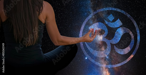 Woman meditating with the universe in the background with buddhist Om sign 