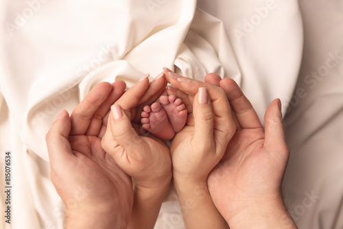Children's feet in the arms of their parents. On a white background.