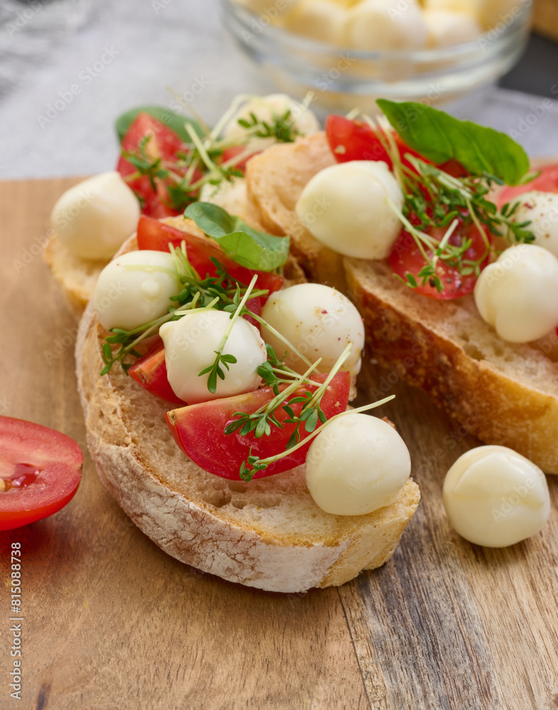 Round mozzarella, cherry tomatoes and microgreens on a piece of white bread, a healthy sandwich Round mozzarella, cherry tomatoes and microgreens on a piece of white bread, a healthy sandwich