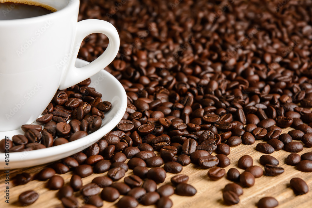 Coffee beans and coffee cup on wooden table Coffee beans and coffee cup on wooden table