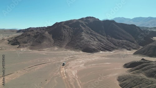 Travesía en 4x4 a través de paisaje montañoso árido desolado inhóspito en una quebrada de la Puna Argentina visto desde drone. (4) photo