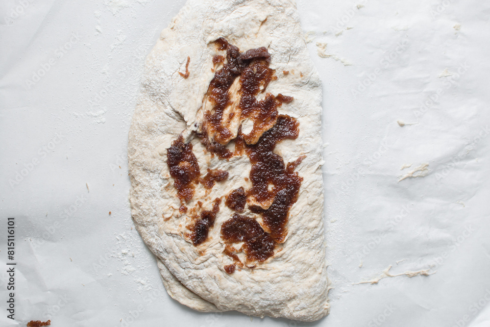 Fototapeta premium Overhead view of date jam on bread dough, flatlay of date jam on sourdough, process of making bread