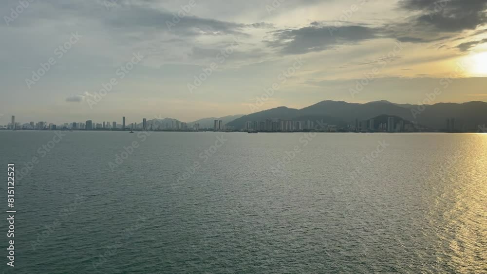 distant panorama view of George Town shorefront and skyline Penang, Malaysia during sunset as seen from a ship distant panorama view of George Town shorefront and skyline Penang, Malaysia during sunset as seen from a ship