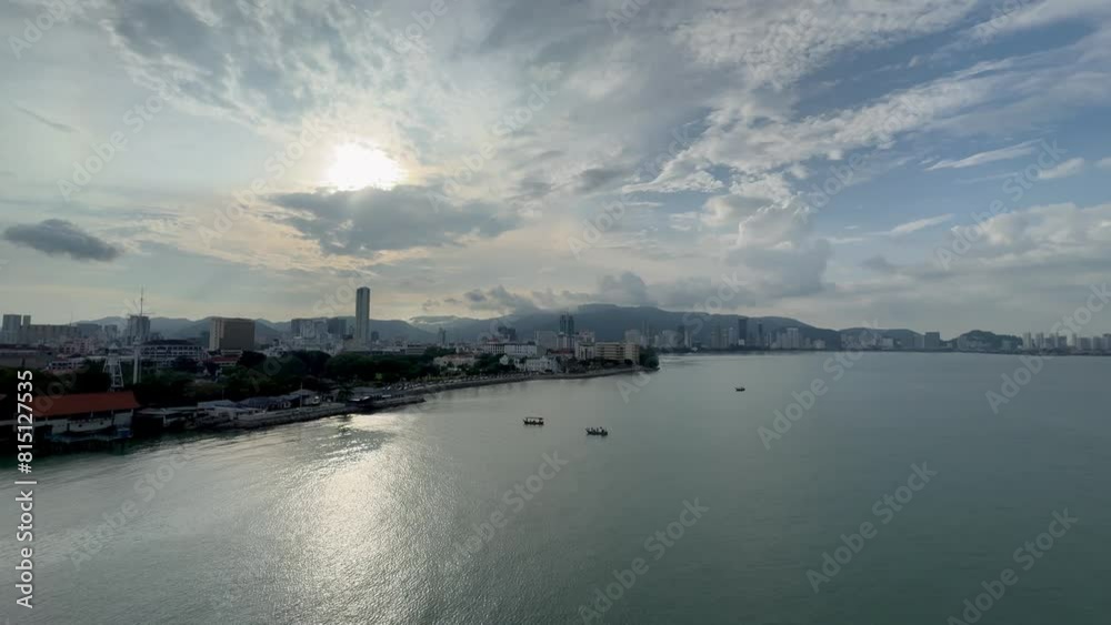 calm early evening vibes over George Town, Penang, Malaysias shorefront with small boats enjoying the sunny, partly cloudy day calm early evening vibes over George Town, Penang, Malaysias shorefront with small boats enjoying the sunny, partly cloudy day