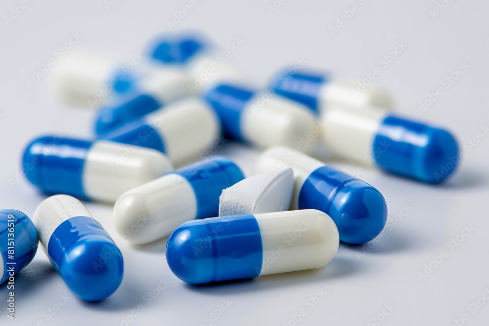 A pile of blue and white pills on a white surface. A pile of blue and white pills on a white surface.
