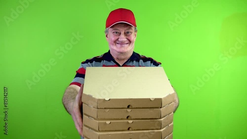 Mature delivery man hands pizza boxes to customer and smiles. photo