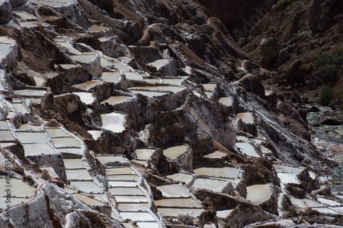 Salt evaporation tanks embedded in a mountain in the city of Maras in Peru photo